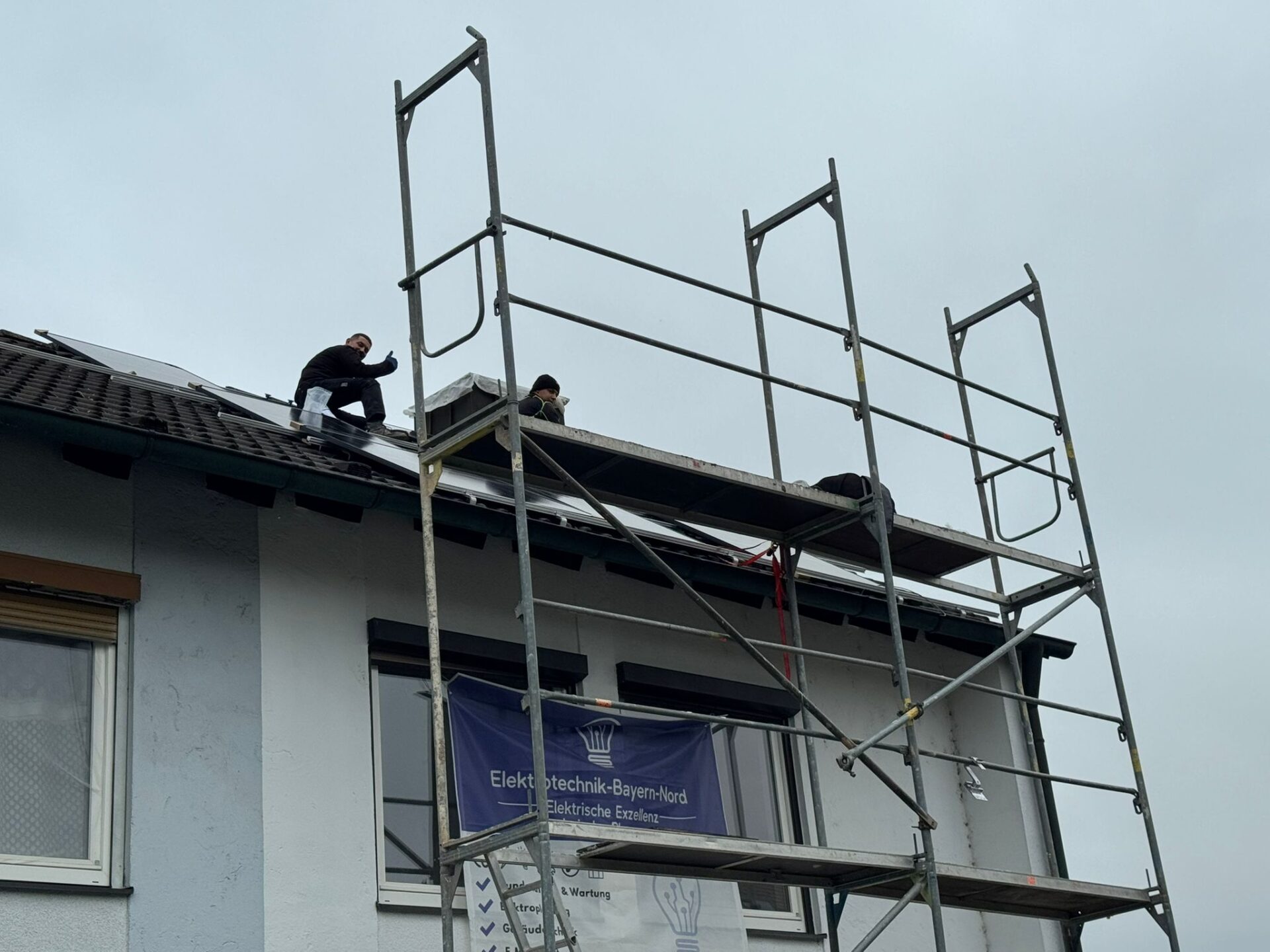 Monteur von Elektrotechnik Bayern Nord montiert Solarmodule auf einem Dach im Würzburger Steinbachtal