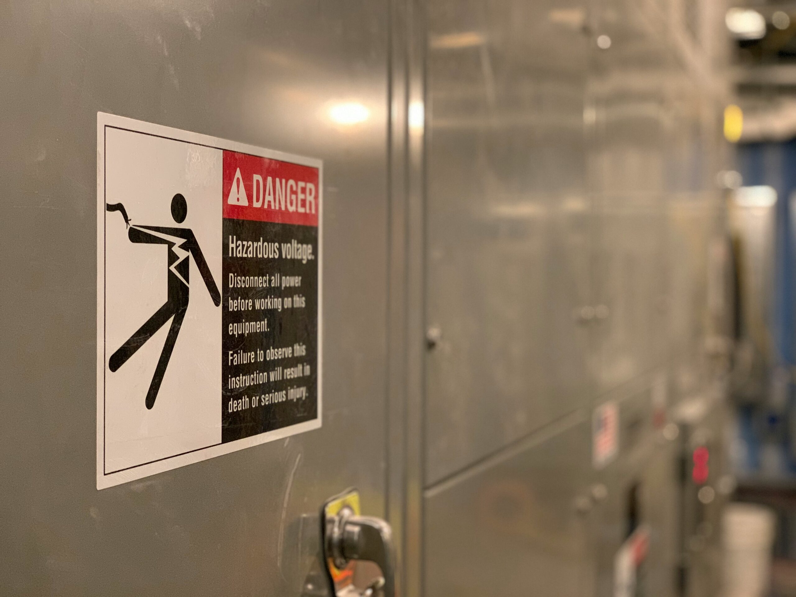 Warnschild vor gefährlicher Spannung an Schaltschrank