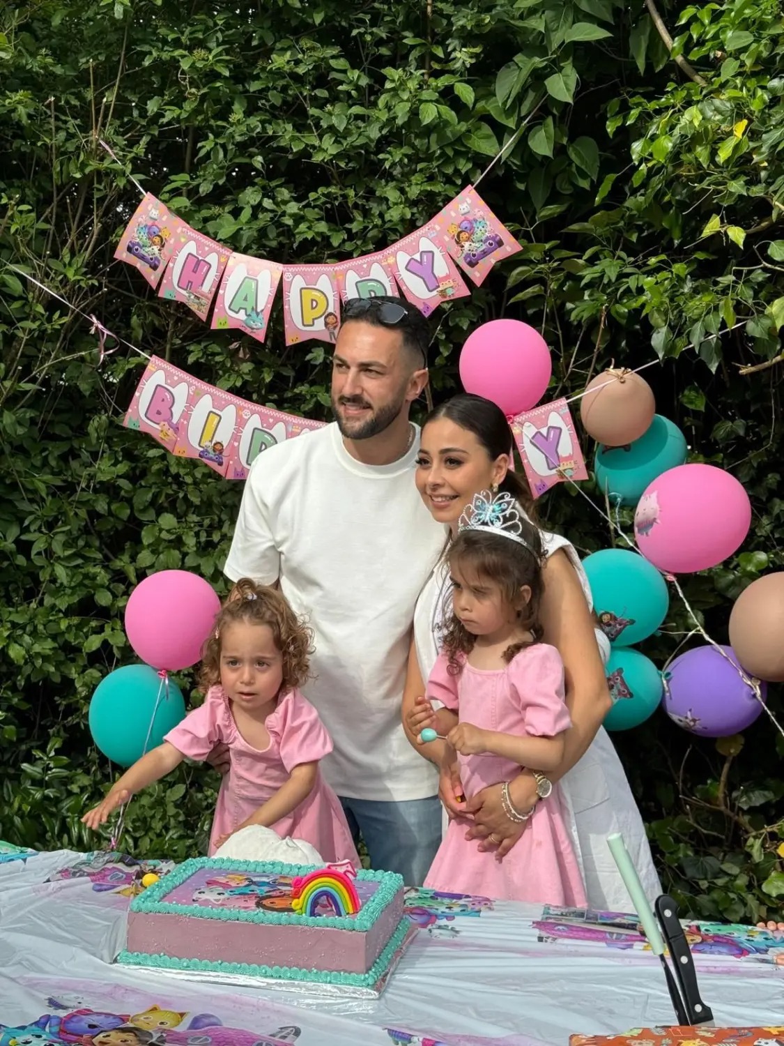 Familie mit zwei Mädchen bei einer Geburtstagsfeier im Garten