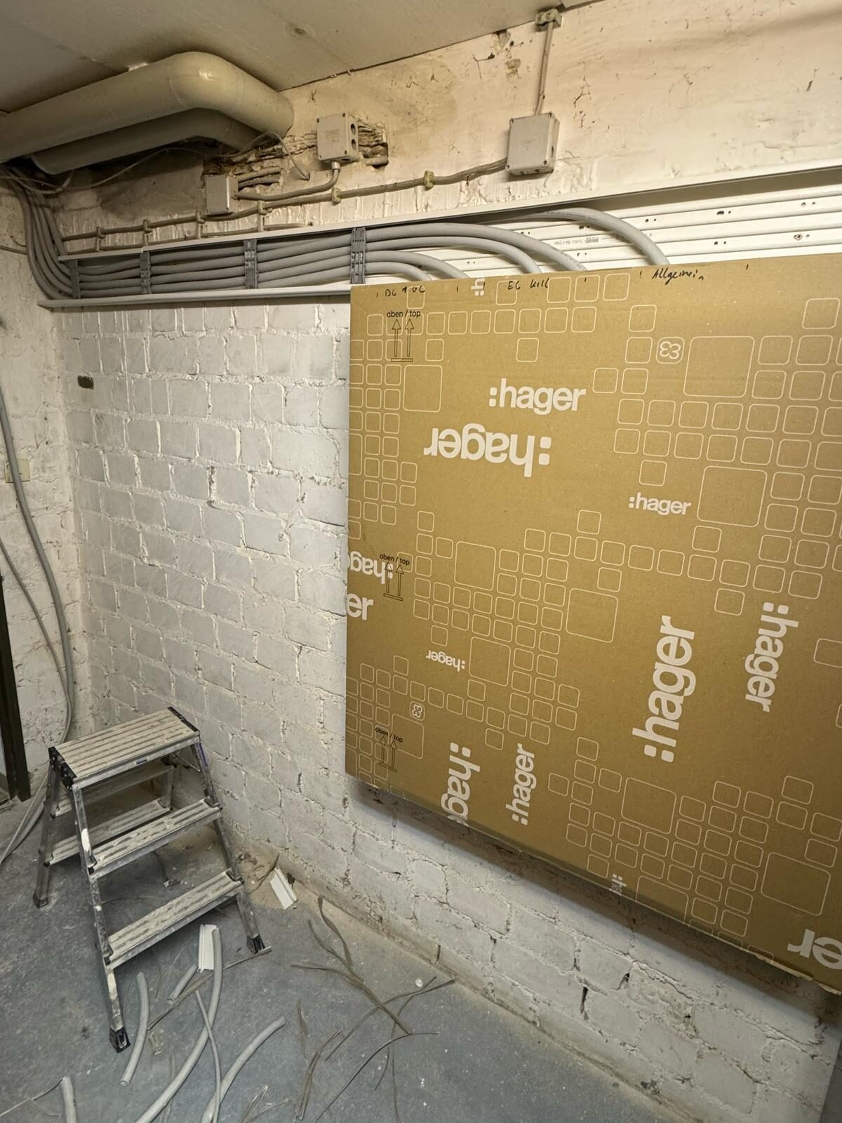 Kabelinstallation an der Wand mit Trittleiter.