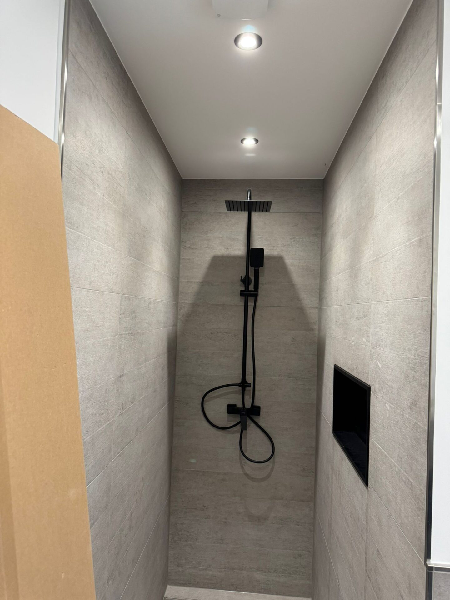 Moderne Dusche mit schwarzer Regendusche und Deckenspots