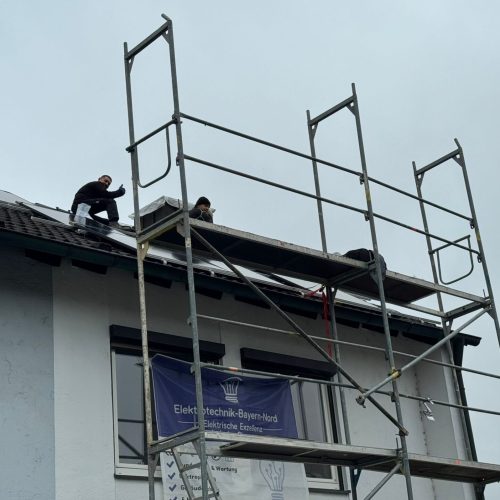 Handwerker installieren Solaranlage auf einem Dach.