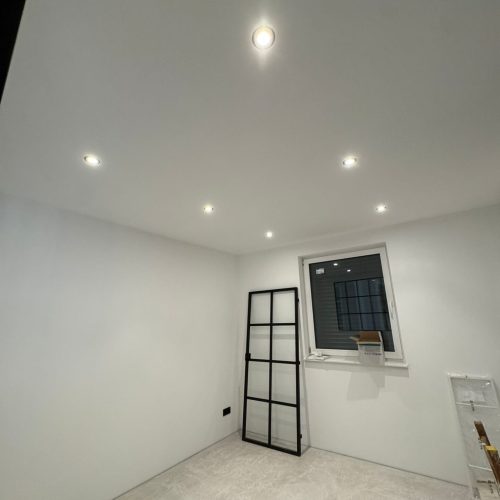 Minimalistisches Zimmer mit Deckenlampen und Fenster.