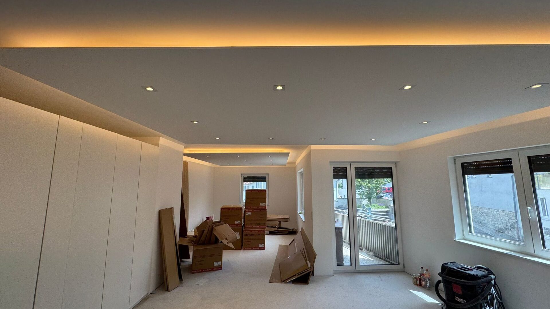 Renoviertes Zimmer mit Kartons und Fenster.