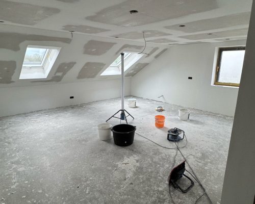 Renovierungsarbeiten mit Eimern und Werkzeug im Dachgeschoss