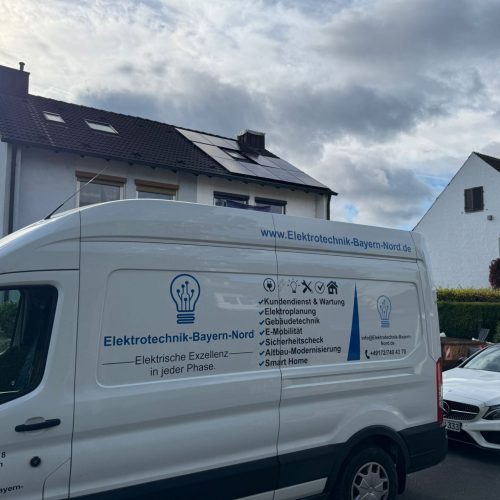 Transporter vor Wohnhaus mit Solardach.